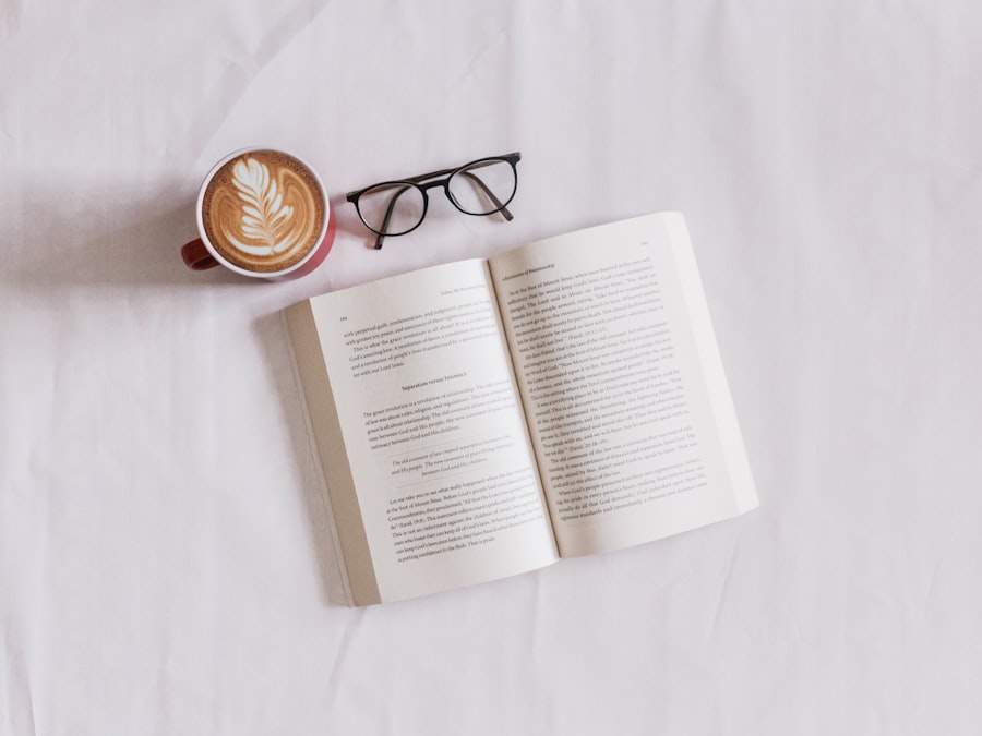Aufgeschlagenes Buch mit Lesebrille und einer Tasse Kaffee