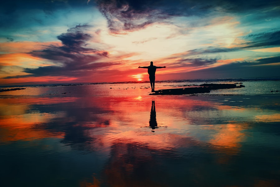 Silhouette eines Menschen im Sonnenuntergang am Wasser